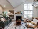 Inviting living room with a cozy fireplace, a stylish green sofa, and plenty of natural light at 1103 Mallory Ln, Durham, NC 27713