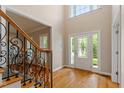 Bright foyer featuring hardwood floors, a staircase, and a decorative front door at 1153 Litchborough Way, Wake Forest, NC 27587