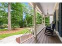 Inviting covered porch with rocking chairs and a view of the landscaped front yard at 11619 Appaloosa W Run, Raleigh, NC 27613