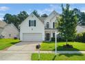 Lovely two-story home with a lush front lawn, green foliage, and a welcoming front entrance at 121 Trevor Ridge Dr, Holly Springs, NC 27540