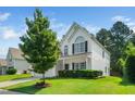 Side view of a beautiful two-story home featuring a well-maintained lawn and mature landscaping at 121 Trevor Ridge Dr, Holly Springs, NC 27540