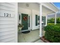 Inviting front porch with decorative wreath, green door, potted plant, and bench seating at 121 Trevor Ridge Dr, Holly Springs, NC 27540