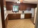 A kitchen featuring wood cabinets, laminate counters, an appliance package, and durable vinyl flooring at 1225 Fairlane Rd, Cary, NC 27511