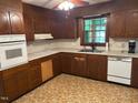 Traditional kitchen with wooden cabinetry, neutral countertops, and white appliances, ready for a modern touch at 1225 Fairlane Rd, Cary, NC 27511