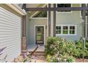 View of home's entrance featuring post and beam architectural detail, stone accents, and beautifully landscaped bushes at 136 Vireo Ln, Hillsborough, NC 27278