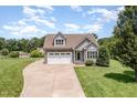 Charming gray two-story home with stone accents, a two-car garage, and a well-manicured front lawn at 14 Water Front Ln, Timberlake, NC 27583