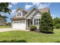 Charming gray two-story home with stone accents, a two-car garage, and a well-manicured front lawn at 14 Water Front Ln, Timberlake, NC 27583