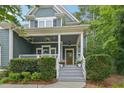 Charming covered front porch with white columns, hanging flower baskets, and a stained wood front door at 1419 Endgame Ct, Wake Forest, NC 27587