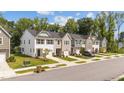 A view of a street with neat townhouses, each featuring a single-car garage and well-kept front lawns at 156 Velvet Ridge Way, Garner, NC 27529