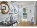 Bright foyer with hardwood floors, staircase, elegant mirror, and glass paneled front door at 18 Clearwater Dr, Durham, NC 27707