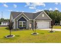 Charming single-story home with gray siding, a two-car garage and a well-manicured lawn and young trees at 19 Linda Lou Ln # 19, Angier, NC 27501