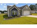Charming single-story home with gray siding, a two-car garage and a well-manicured lawn with flower beds at 19 Linda Lou Ln # 19, Angier, NC 27501