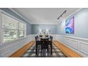 Formal dining room with decorative wainscoting, light blue walls, and a large window at 1926 Downing Dr, Burlington, NC 27215