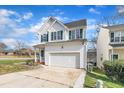 Traditional home with a driveway leading to an attached garage, set against a backdrop of a bright blue sky at 1968 Shadow Glen Dr, Raleigh, NC 27604