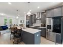 Modern kitchen boasts stainless steel appliances, gray cabinetry, a spacious island, and stylish pendant lighting at 2006 Leo Dr, Apex, NC 27502