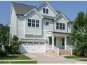 Beautiful home features light blue siding, white trim, well-manicured lawn, attached garage, and inviting entrance at 2013 Woodbluff Dr, Wendell, NC 27591
