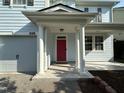 Covered front porch featuring white columns and a vibrant pink front door with a patterned concrete walkway at 205 Bog Hill Ln, Cary, NC 27519
