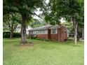 Quaint brick home features lush front yard and ample shade trees at 2100 Breeze Rd, Raleigh, NC 27608
