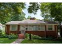 Inviting brick home with landscaped garden and covered front porch at 2100 Breeze Rd, Raleigh, NC 27608