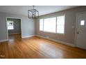 Bright living room with gleaming hardwood floors and large window at 2100 Breeze Rd, Raleigh, NC 27608