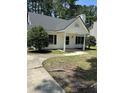 Inviting one-story home with gray roof, featuring a charming front porch and lush landscaping at 2116 Tanglewood Rd, Rocky Mount, NC 27804