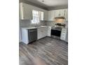 Modern kitchen featuring stainless steel appliances, white cabinets, and granite countertops at 2116 Tanglewood Rd, Rocky Mount, NC 27804
