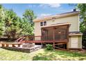 Back of the house featuring a screened porch, wood deck, and brick fire pit at 212 Heidinger Dr, Cary, NC 27511