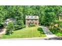 Traditional brick home with a well-manicured lawn and mature trees at 212 Heidinger Dr, Cary, NC 27511