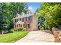 Beautiful two-story brick home featuring dormer windows and mature trees at 212 Heidinger Dr, Cary, NC 27511