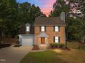 Inviting two-story brick home with gray siding, a tidy yard, and an orange front door at 2205 Bufflehead Rd, Raleigh, NC 27616
