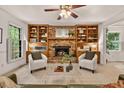 Inviting living room with a brick fireplace, built-in bookshelves, ceiling fan, and neutral tones at 224 Fleming Dr, Durham, NC 27712