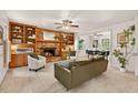 Spacious living room with brick fireplace, built-in shelving, ceiling fan, and an opening to the dining area at 224 Fleming Dr, Durham, NC 27712
