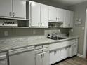 Bright kitchen features white cabinetry, marble countertops, stainless sink, and modern appliances at 2331 Kennington Rd, Raleigh, NC 27610