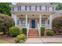 Inviting front porch with brick steps, white railings, and a dark blue front door at 2420 Rogerson St, Raleigh, NC 27614