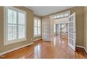 Bright living room with hardwood floors, plantation shutters, and an open doorway to the foyer at 2420 Rogerson St, Raleigh, NC 27614