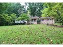 Quaint one-story home with a spacious front lawn covered in autumn leaves and lush foliage at 2440 Gardner Holt Rd, Burlington, NC 27215
