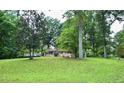 Single-story home nestled among mature trees, offering privacy and a serene setting at 2440 Gardner Holt Rd, Burlington, NC 27215