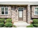 Close-up of the front door showcasing the stone facade and manicured shrubs at the townhome entrance at 2808 Carter Finley Pl, Raleigh, NC 27606