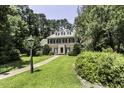 A stately brick home surrounded by trees and manicured greenery sits on a lush green lawn at 3112 Lake Pointe Trl, Rocky Mount, NC 27804