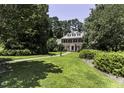 Lush green lawn surrounds this stately home with mature trees and manicured landscaping at 3112 Lake Pointe Trl, Rocky Mount, NC 27804