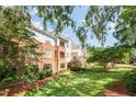 View of condominiums with brick and siding, along with lawn and mature trees at 3701 Baron Cooper Pass # 303, Raleigh, NC 27612