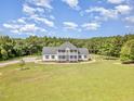 Expansive front yard leading up to a beautiful home with a manicured lawn at 407 Kadir Womble Dr, New Hill, NC 27562