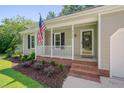 Inviting front porch with a charming white railing and landscaped flower bed at 4140 Willow Haven Ct, Raleigh, NC 27616