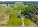Expansive aerial view of home and surrounding acreage, featuring lush green fields and distant buildings at 419 Mabry Rd, Angier, NC 27501