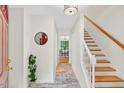 Inviting entryway featuring tile flooring, staircase, a round mirror, and a view into the dining room at 508 Bolin Creek Dr, Carrboro, NC 27510