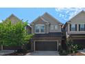 Two-story townhome exhibits a well-kept exterior, a dark colored garage door, and a blue sky above at 536 Rockcastle Dr, Cary, NC 27519
