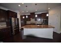 Modern kitchen featuring dark wood cabinets, granite countertops, and stainless steel appliances at 536 Rockcastle Dr, Cary, NC 27519