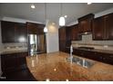 Well-appointed kitchen boasts dark wood cabinets, stainless steel appliances, and a functional center island at 536 Rockcastle Dr, Cary, NC 27519