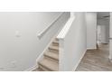 Carpeted staircase with white handrails leads to the upper level, adjacent to wood-look floors at 5556 Henley Ridge Dr, Graham, NC 27253
