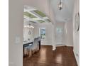 Elegant dining room with hardwood floors, coffered ceilings, stylish chandelier, and ample natural light from the window at 601 Minerva Dale Dr, Fuquay Varina, NC 27526